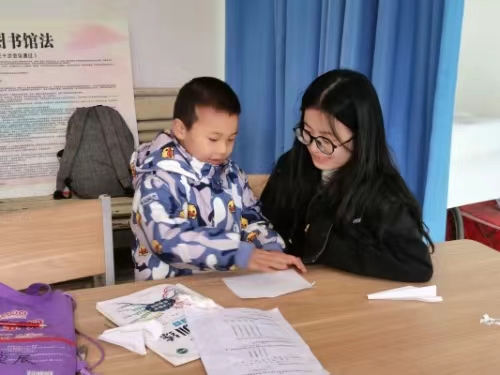 ea782b7a05914fc2b92c50d9c92075fa.jpg 志愿者为儿童讲解作业.jpg